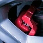 Czerwony zacisk hamulcowy i tarcza hamulcowa w samochodzie