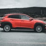 Czerwony Peugeot 2008 SUV zaparkowany na zewnątrz w pochmurny dzień