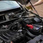Mechanik sprawdza komorę silnika Peugeota podczas przeglądu