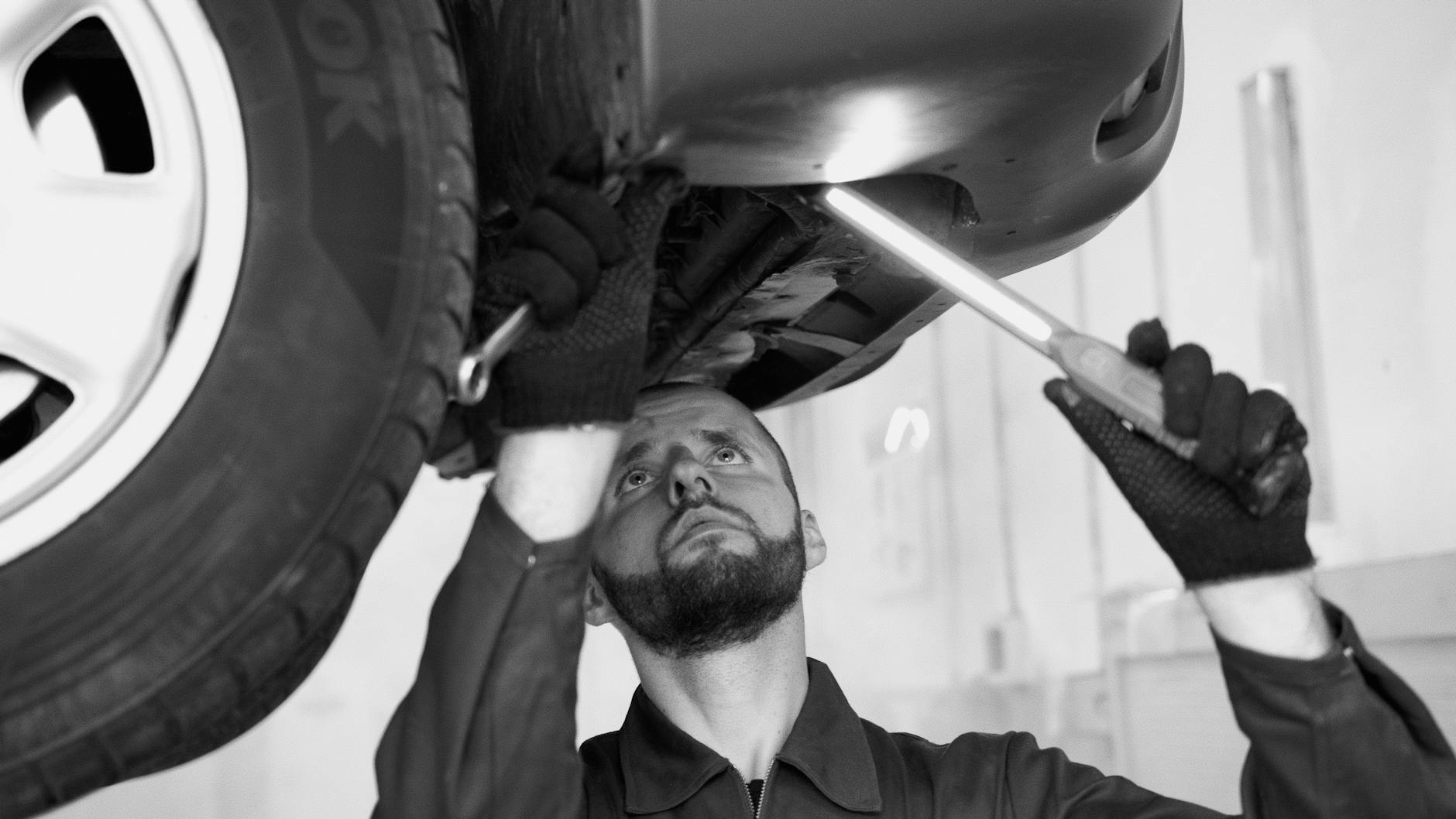 Mechanik sprawdza podwozie Peugeota w warsztacie podczas diagnostyki ABS
