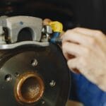 Mechanik sprawdza stan tarczy i klocków hamulcowych w Peugeocie