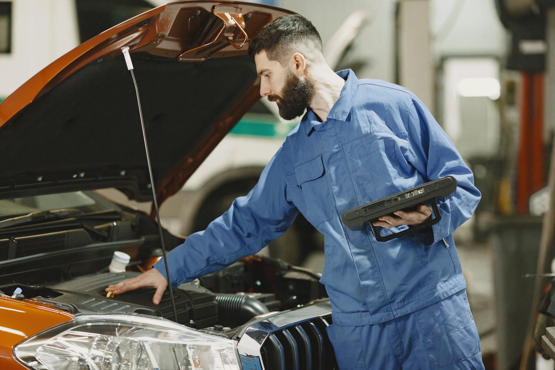 Mechanik w warsztacie sprawdza silnik Citroëna DS3 pod otwartą maską