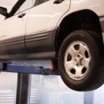Biały Citroën na podnośniku w warsztacie samochodowym